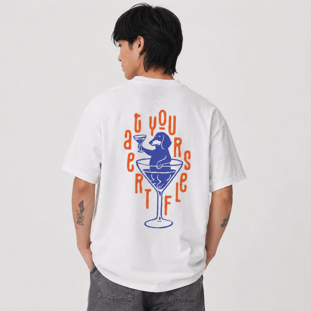 A man wearing a white t-shirt from the back, featuring a graphic print of a blue martini glass with a dog inside and orange text reading 'Treatyourself'.