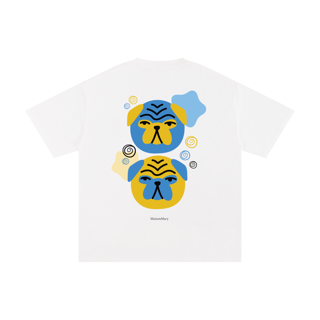 A white short-sleeve crewneck t-shirt featuring a graphic print of two stylized pug faces in blue and yellow, with small decorative swirls and the brand name masionmary